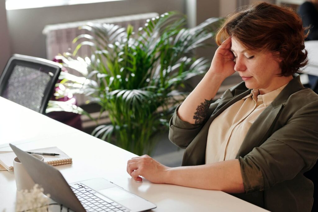 A woman touching her head while her eyes are closed