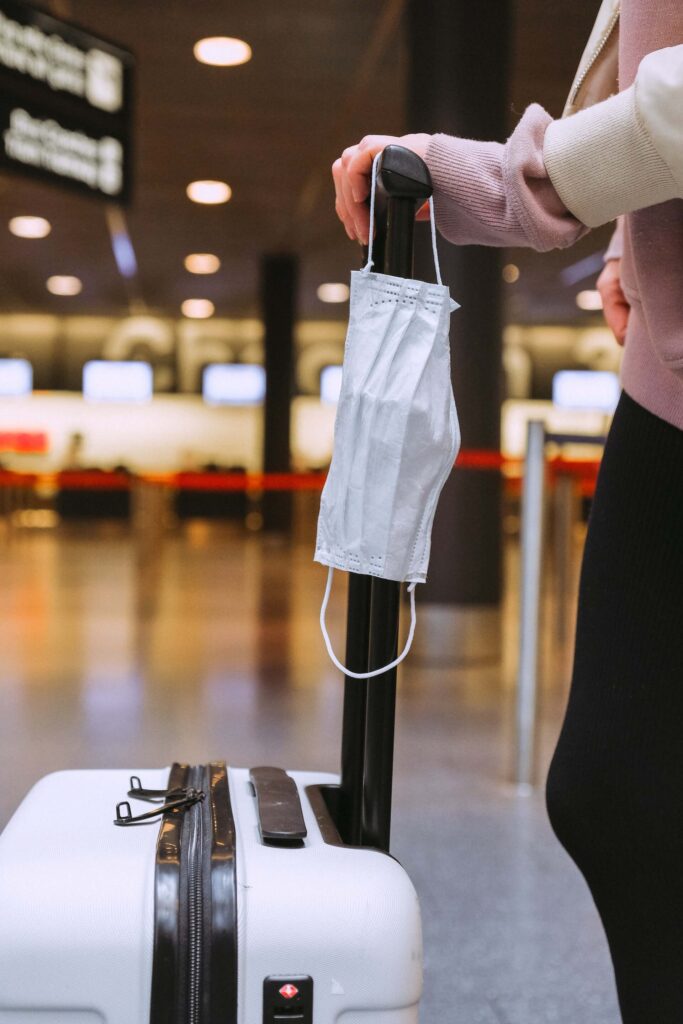 Holding the luggage handle with mask to go abroad