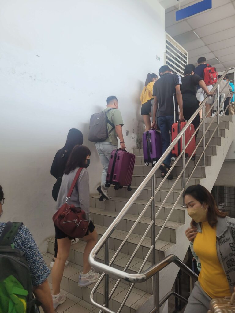 People carrying their things up the stairs in Padang Besar